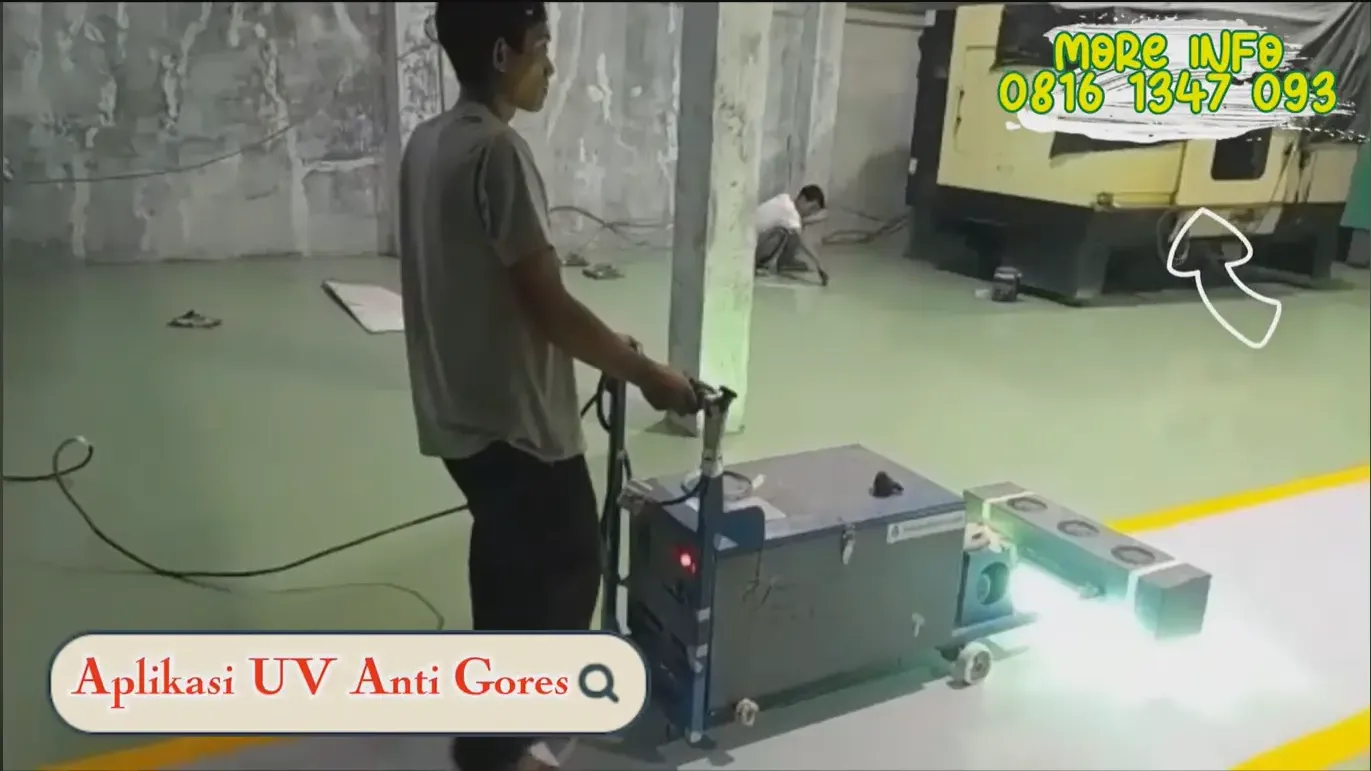 Pekerja mendorong mesin lampu UV di atas lantai epoxy area produksi